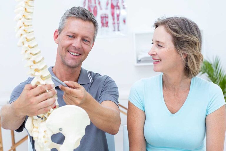 Person resting in bed while a clinician discusses neck pain and sleep posture using a simple diagram
