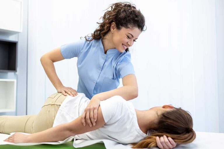A chiropractor explaining pain patterns using a spine model during a consultation with a resident.