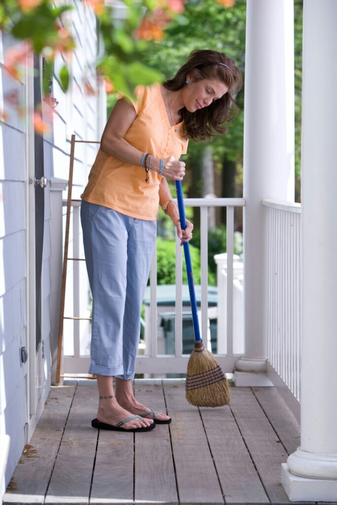 Person lifting a laundry basket close to the body with knees bent and a neutral back.